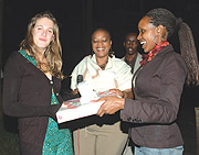Kitty Llewellyn (L) receives a gift from The New Timesu2019 Managing Editor, Grace Kwinjeh (C)