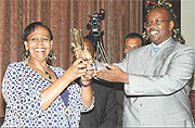 Minister Musoni presents an accolade to Gahaya Linku2019s Joy Ndungutse. (Photo/ G. Barya).