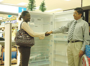 Seynabou Sy-Daff receives the refrigerator from Thiagarajan Ramamurthy, the Nakumatt Holdings Director of Operations. (Photo G Barya).