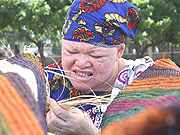 An albino woman weaves a traditional carpet in the Tanzanian city of Dar es Salaam.