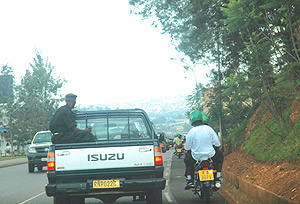 FLOUNTING THE LAW IN FULL VIEW OF THE LAW: Motorcyclists carrying passengers overtake a Police car on the wrong side of the road and get away with it. (Photo/ J. Mbanda).