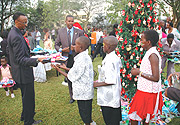 President Kagame handing Christmas gifts to children. (Photo/J. Mbanda).