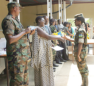 A Student receives  a certificate from the Education Minister Daphrose Gahakwa upon completion of Ingando at Gako Military Academy yesterday. (Photo / S. Nkurunziza).