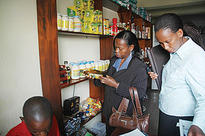 Commerce Minister Monique Nsanzabaganwa (L) closely looks at the expiry date of some items in a shop during the inspection exercise yesterday. (Photo J Mbanda).