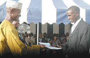 The minister of Internal Security Musa Fazil Harerimana handing over a certificate to the best police officer, Syverien  Rukundo yesterday at the police headquaters. (Photo G.Barya).