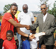 Ayew offering his donations to Damas Gisimba, Director of the orphanage centre (courtesy photo)
