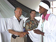 Senator John Lim shaking hand sof a tailoring student. (Photo/ Eugene Mutara).