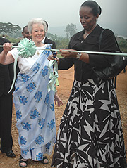 First Lady Jeannette Kagame with  Rosemary Jensen, the president the Foundation, cutting the ribbon to launch Rafiki Village in Bugesera  yesterday. (Photo/G.Barya).
