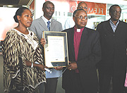 Bishop John Rucyahana with his wife displaying the Award from United States on Arrival at Kigali International Airport Yesterday. (Photo/ G.Barya).