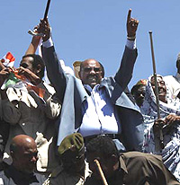 A defiant Omar al Bashir surrounded by supporters on his recent trip to Darfur.