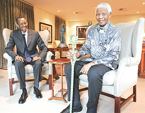 President Kagame with former South African President Nelson Mandela at the latteru2019s residence yesterday. Mandela clutches a walking stick given to him as a gift by President Kagame. (PPU Photo).