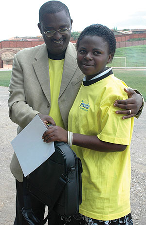 Minister Theoneste Mutsindashyaka hands a laptop to Marie Louise Uwiduhaye, the best female student at the function organised by Imbuto Foundation yesterday. (Photo/ G.Barya)