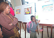 Laissa Umutesiwase points at her painting which took first place in the of 5-9  age group. (Photo/ J. Mbanda).