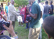 Fina Bank staff hands bags to Gisimba orphans on Saturday. (Photo/ G. Mugoya).