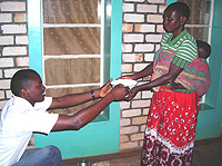 Leonard Semayira serves food to care giver at the Butare Teaching Hospital. (Photo Ntambara).