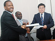 The Managing Director of Ultimate Concepts Leopold Mukama (L) shakes hands with Zhang Weize the General Manager B C E G after signing, as CSR Director General Henry Gaperi (2nd L) look on. (Photo/ J Mbanda).