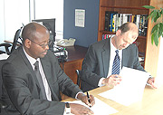 Finance Minister James Musoni and the WB country director, Johannes Zutt signing the agreement in Washington. (Courtesy photo).