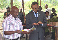 Aimable Gakirage, Director General of EAG (L) showing President Paul Kagame (R) imported French bean seeds.