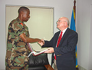 Gen. James Kabarebe hands a gift to William Huntington, after their meeting at the formeru2019s office. (Courtsey Photo).