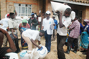 UNHCR and Red Cross staff supervising the distribution of food to returnees from Uganda at the Rwanda Red Cross Headquarters in Gacuriro before they were transported to their respective districts. (Photo / J Mbanda)