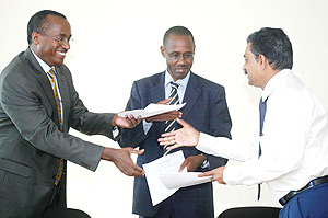 George Rubagumya of Olyana Holdings, Anthony Butera of Ocir-The and Srinivasa Rao, exchanging papers after signing the agreement at RDB Offices yesterday. (Photo/G. Barya).