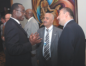 Prime Minister Bernard Makuza (L) making a point to Abdurrahman Atila (R) and Munur Karagozlu both of INSICAM Construction based in Kampala during the Construction/Real Estate Investment Roundtable yesterday. (Photo/ J Mbanda).
