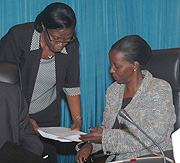 Hon. Bernadette Kanzayire (L) consults with Information Minister Louise Mushikiwabo at Parliament yesterday. (Photo/ J. Mbanda).