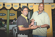 MR. CONSISTENCY: Phillip Jacob receives his winneru2019s gong from MTN Rwandau2019s sponsorship manager John Bosco Sendahangarwa. It was Jacobu2019s third successive mug in the second group (Handicap 10-18). (Photo/ G. Barya)