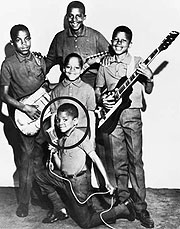 The 5 Jacksons pose for a group photo with their music instruments
