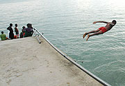 A boy dives into the water while others look on. (File photo)