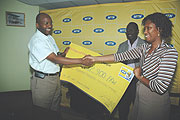 Robert Masozera (L) receives the cheque from MTNu2019s Jessie Kalisa.