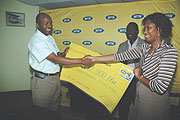 Robert Masozera (L) receives the cheque from MTNu2019s Jessie Kalisa.