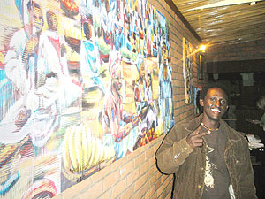 Bakunzi stands besides one of his u2018Crowdu2019 paintings at Heaven reastaurant in Kiyovu (Photo by Gloria A.)