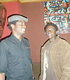 Collin Ssekajugo (L), founder of Ivuka art Studio, poses for a photo with Bakunzi (R).