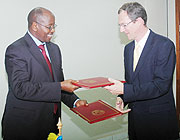  Finance Minister, James Musoni (L), and Head of DFID Rwanda Martin Leach exchange documents  after signing a 107 Million Pound MOU on Tuesday (Photo J Mbanda).