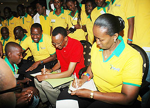 President Paul Kagame and First Lady Jeannette sign autographs for the youth after the meeting. (Photo J Mbanda)