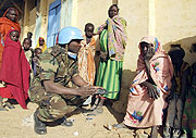 A UNAMID peacekeeper talks to displaced women in Darfur