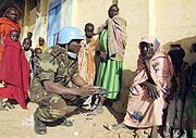 A UNAMID peacekeeper talks to displaced women in Darfur