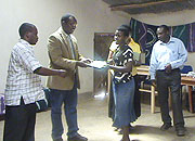 A participant receives a certificate of merit from UNHCR National Health Coordinator Dr Augustin Gatera (Photo S Nkurunziza)