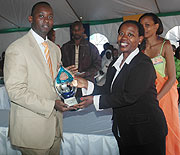 Rwandatel Director General Patrick Kariningufu receiving a trophy from Commerce and Industry Minister Monique Nsanzabaganwa after emerging best exhibitor. (Photo J Mbanda)