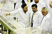 Iranian President Mahmoud Ahmadinejad, center, listens to a technician in a nuclear fuel manufacturing plant in Isfahan, Iran