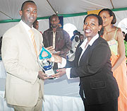 Rwandatelu2019s CEO, Patrick Kariningufu receiving a trophy from the Trade and Industry Minister, Monique Nsanzabaganwa after emerging best overall exhibitor. (Photo J Mbanda).