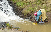A woman fetches water in one of the water sources  in Ruhengeri.(Photo B Mukombozi).