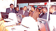 Mr.Hassan Rucyemangabo CEO of Dash S Technologies Inc. (third left) showing President Paul Kagame assorted techologies used in championing a paperless environment within the modern work environment.