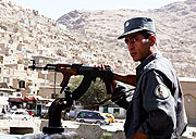 An Afghan policeman keeps watch after rockets hit Kabul in advance of the 2009 presidential election.