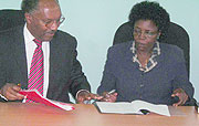 Dr Charles Karemangingo and Prof. Mary Okwakol during the signing of the agreement. (Photo: B. Mukombozi)