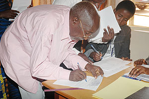 One of the former evictees signing for his cheque (Photo F. Goodman ). 