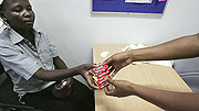 A patient receives condoms from a consultant in Kampala, Uganda.