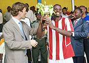 Brwalirwa Managing Director hands over a trophy to Entircelles FC player after the football match (Courtesy Photo).