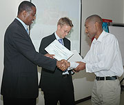 Youth Minister Protais Mitali hands a certificate to an ALCP graduand at the event .(Photo F Goodman)